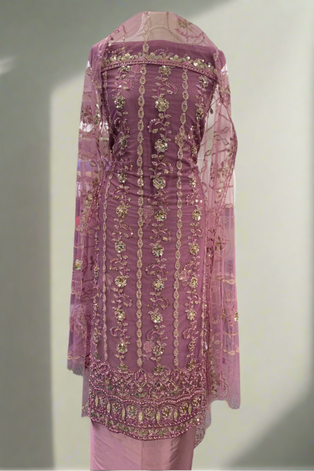 Pink embroidered traditional outfit in a store setting