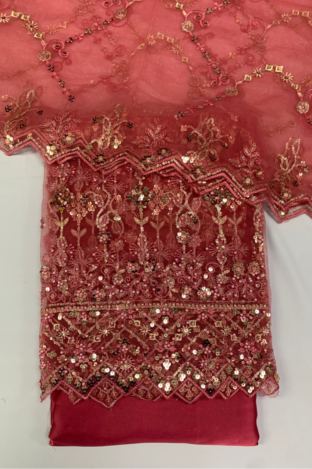 Red fabric with gold embroidery on a white background