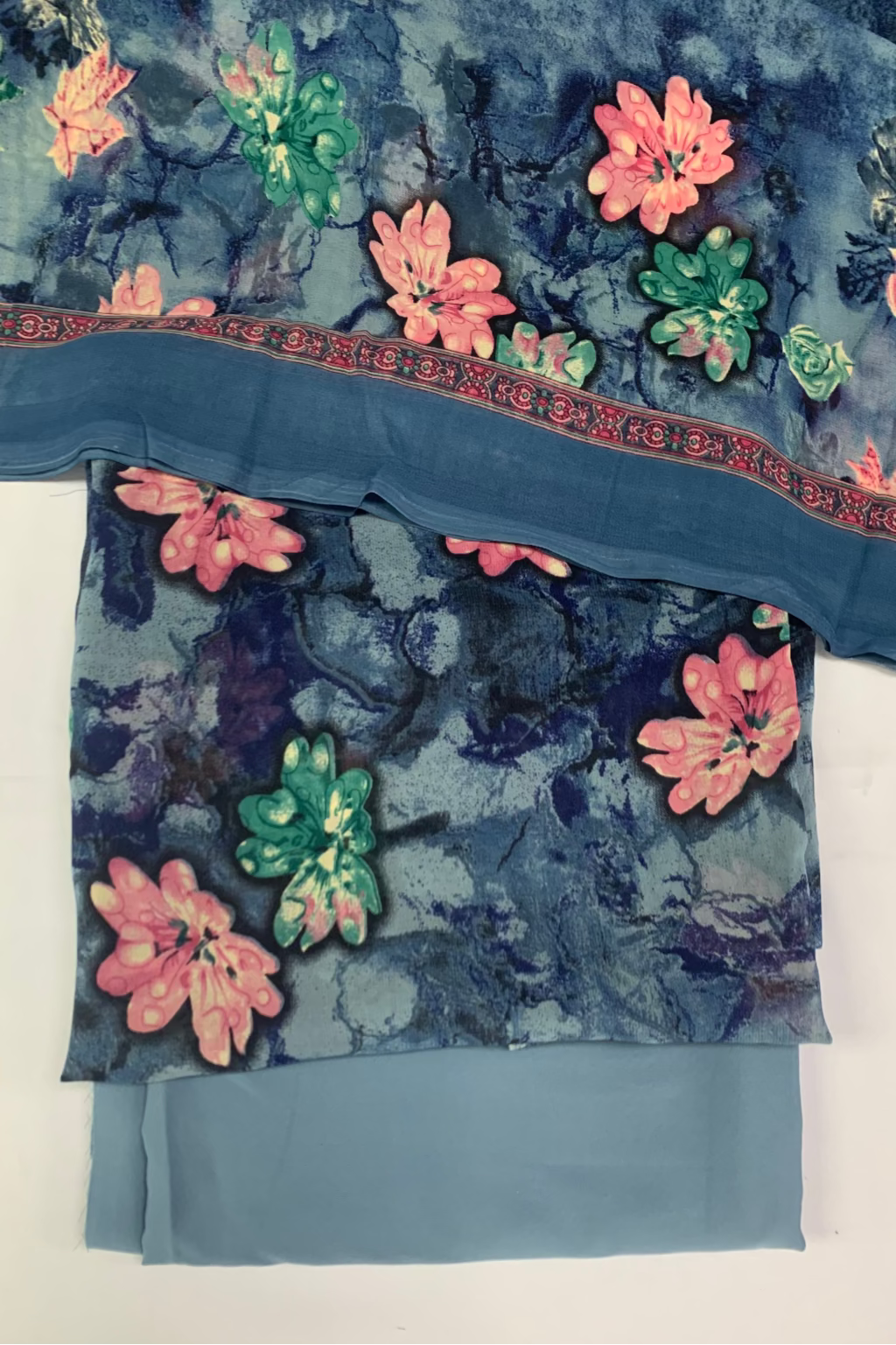 Blue floral fabric with pink and green flowers on a white background