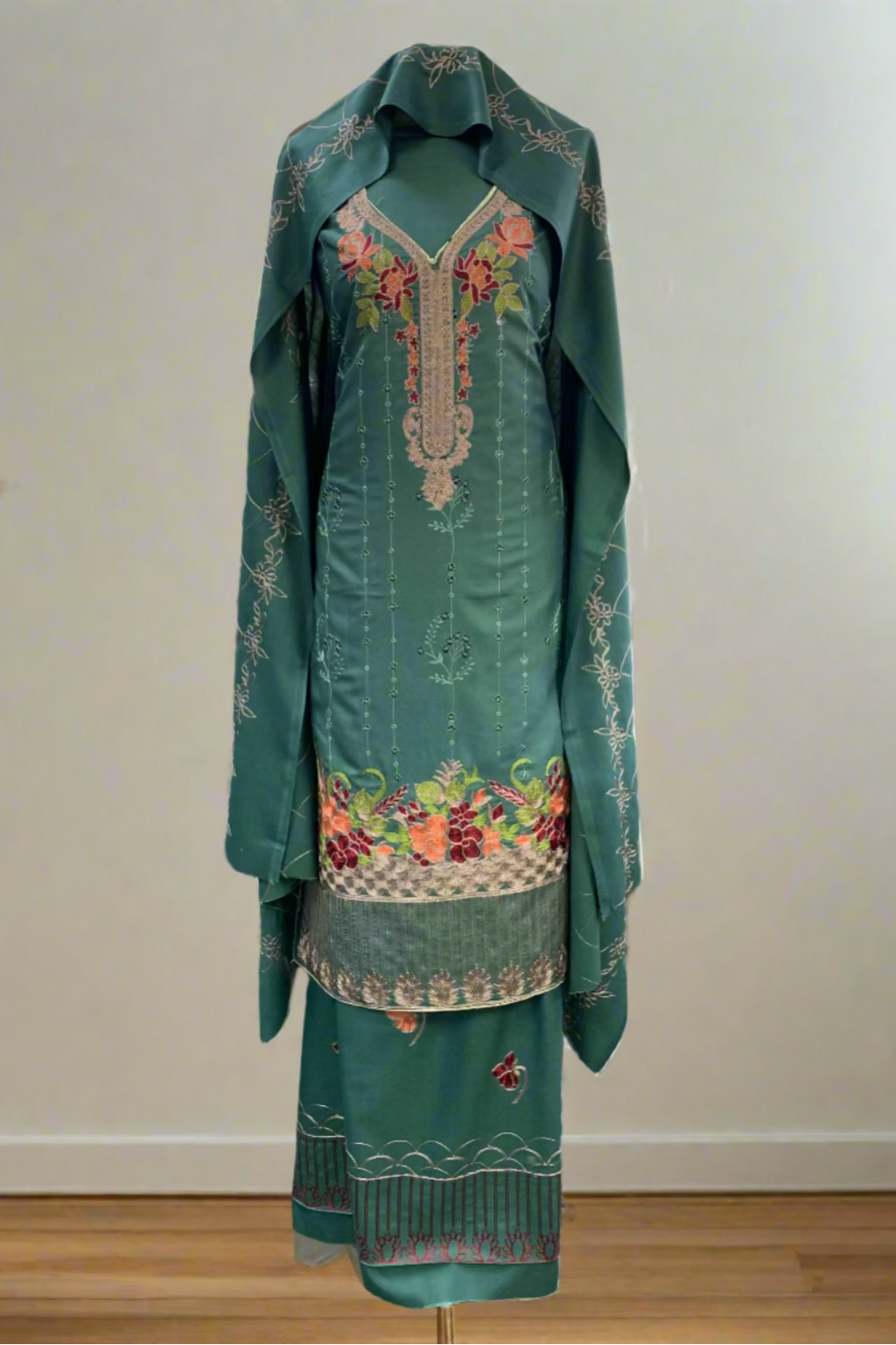 Green embroidered traditional outfit in a store setting