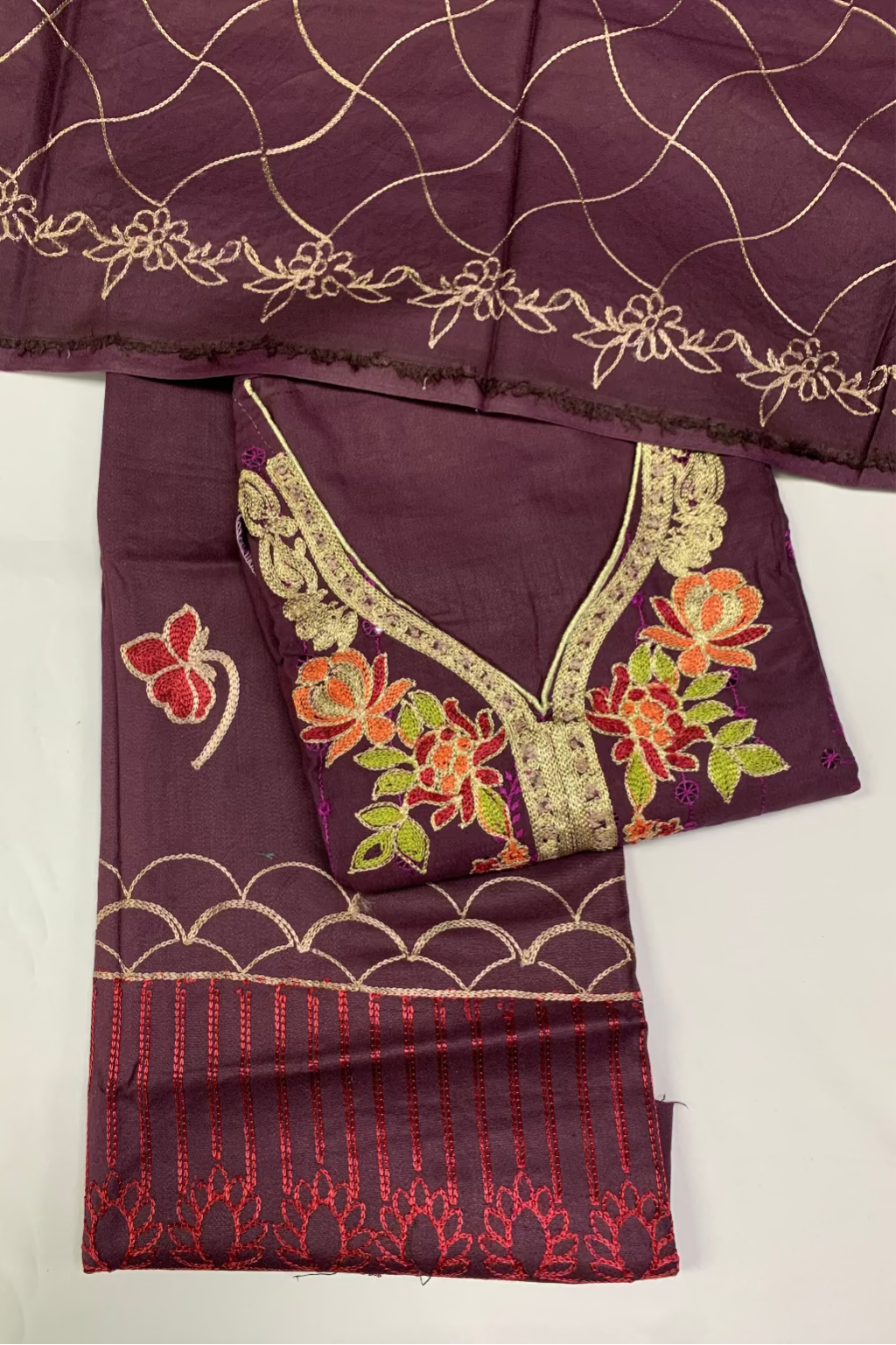 Embroidered purple fabric with floral designs on a white background