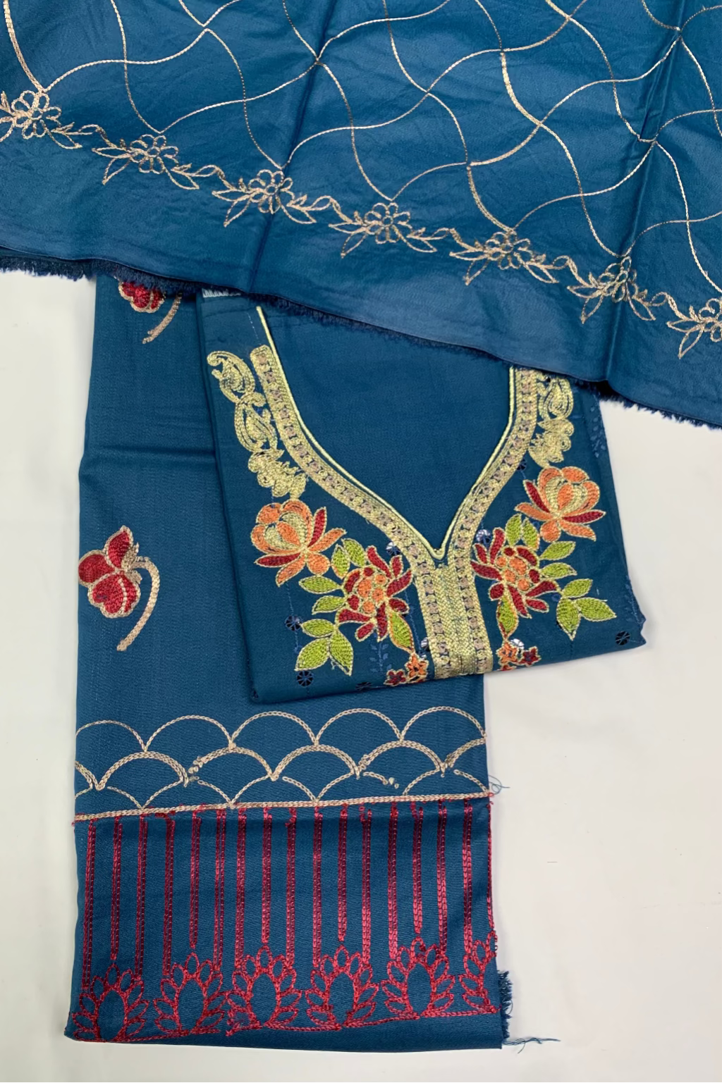 Blue fabric with intricate patterns and embroidery on a white background