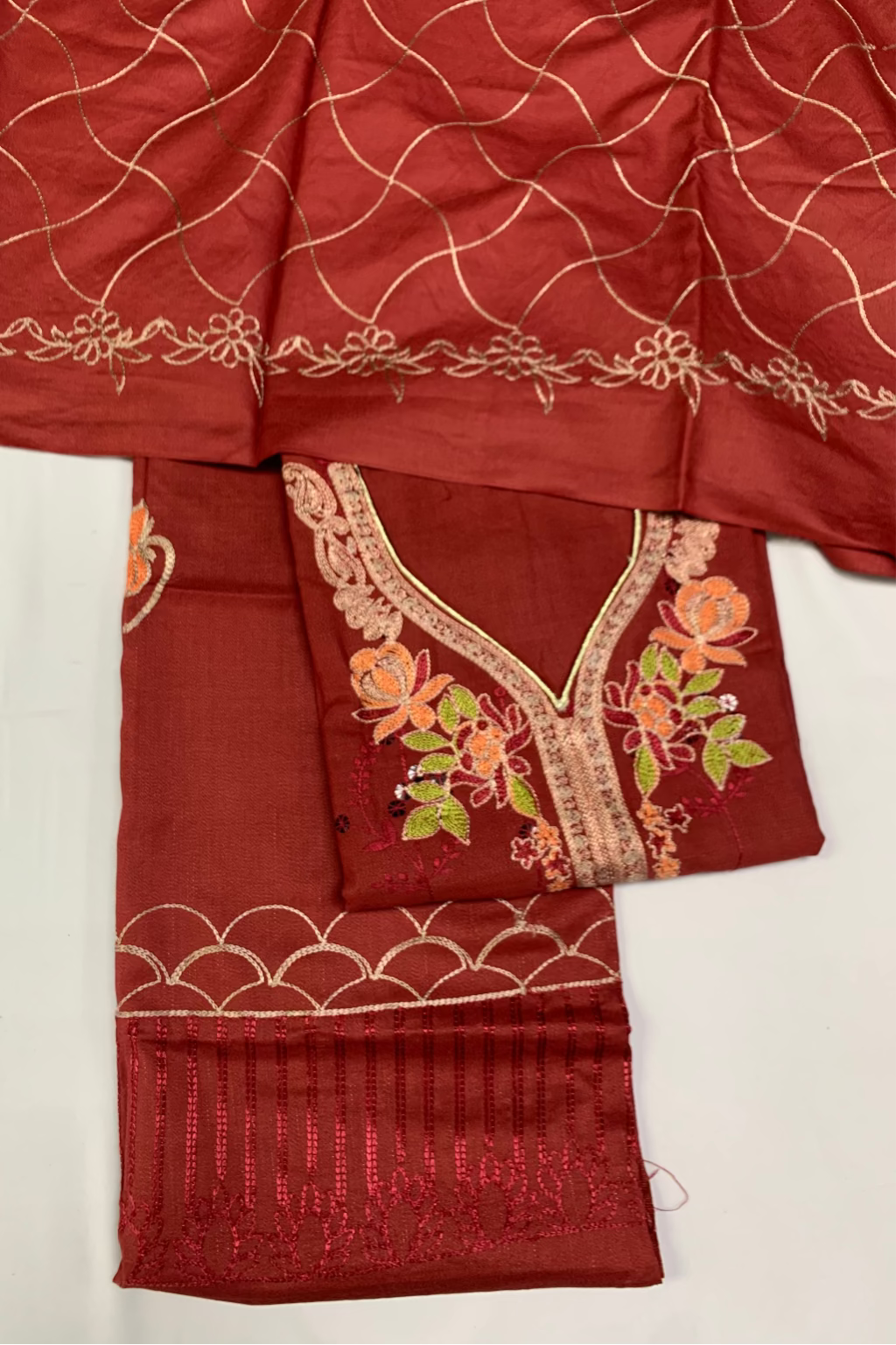 Maroon fabric with floral embroidery on a white background