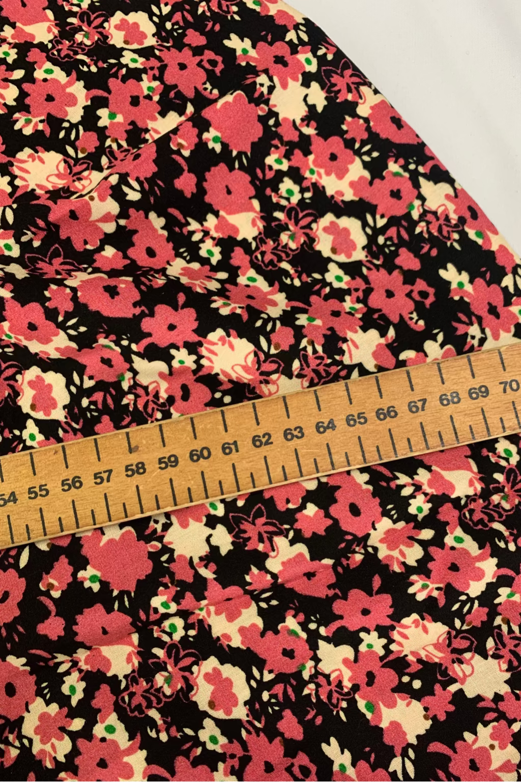 Floral fabric with a ruler for scale on a white background