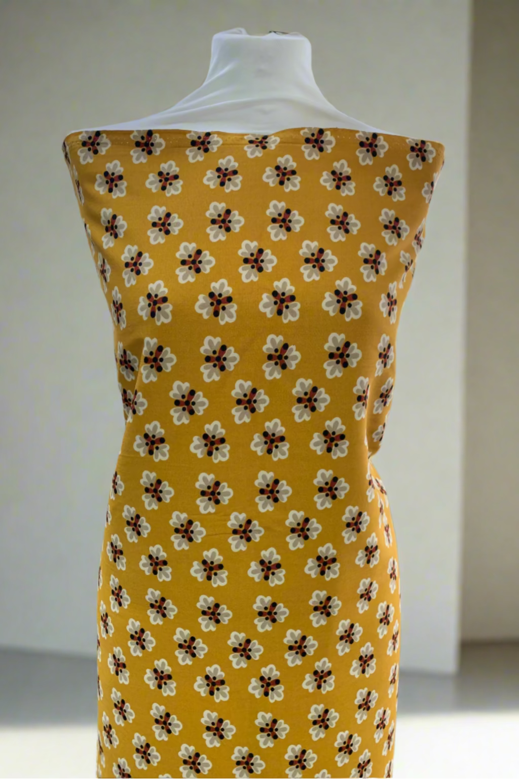 Yellow dress with floral pattern on a mannequin in a store setting