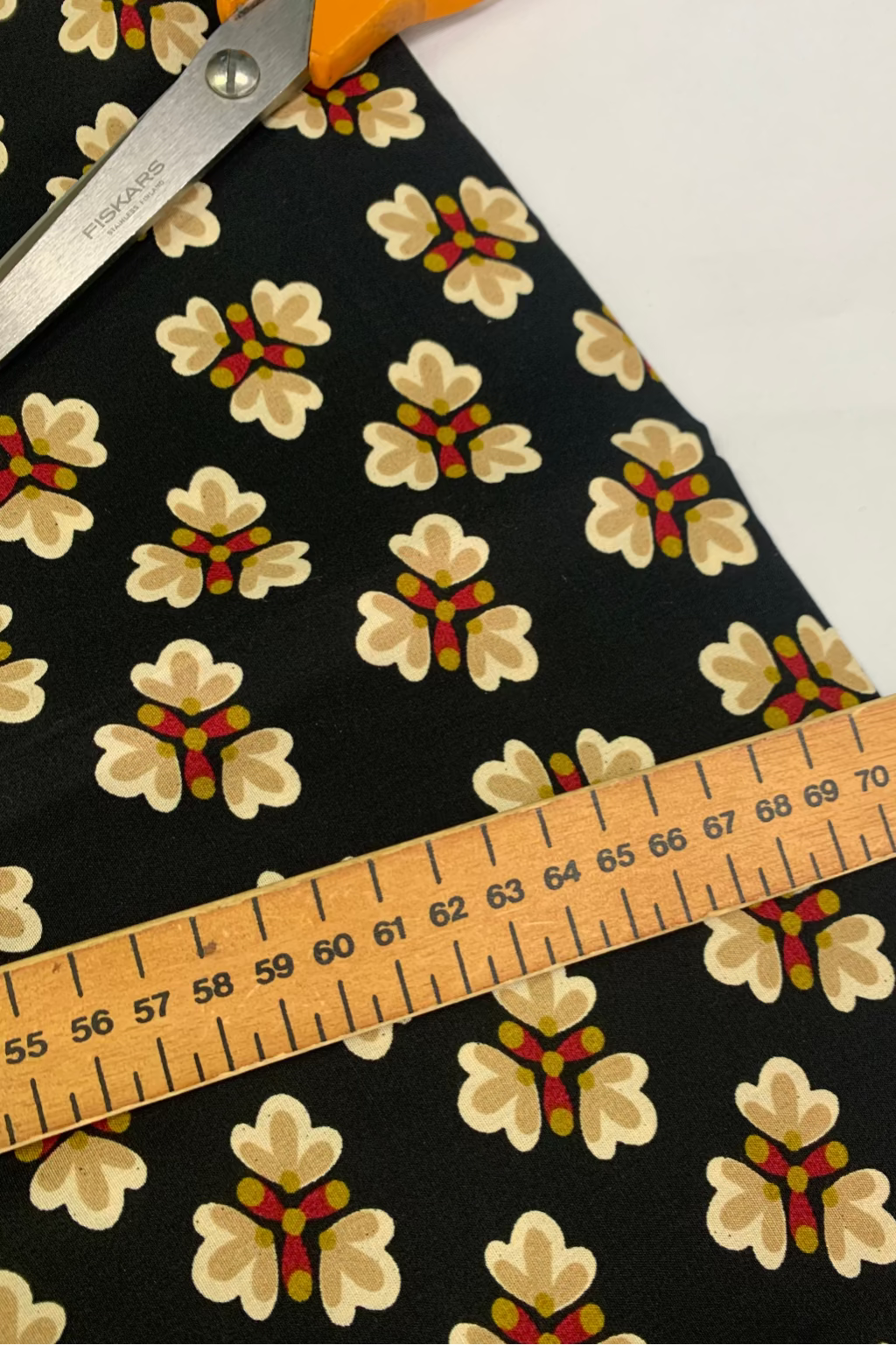 Floral-patterned fabric with a ruler for measurement on a white background