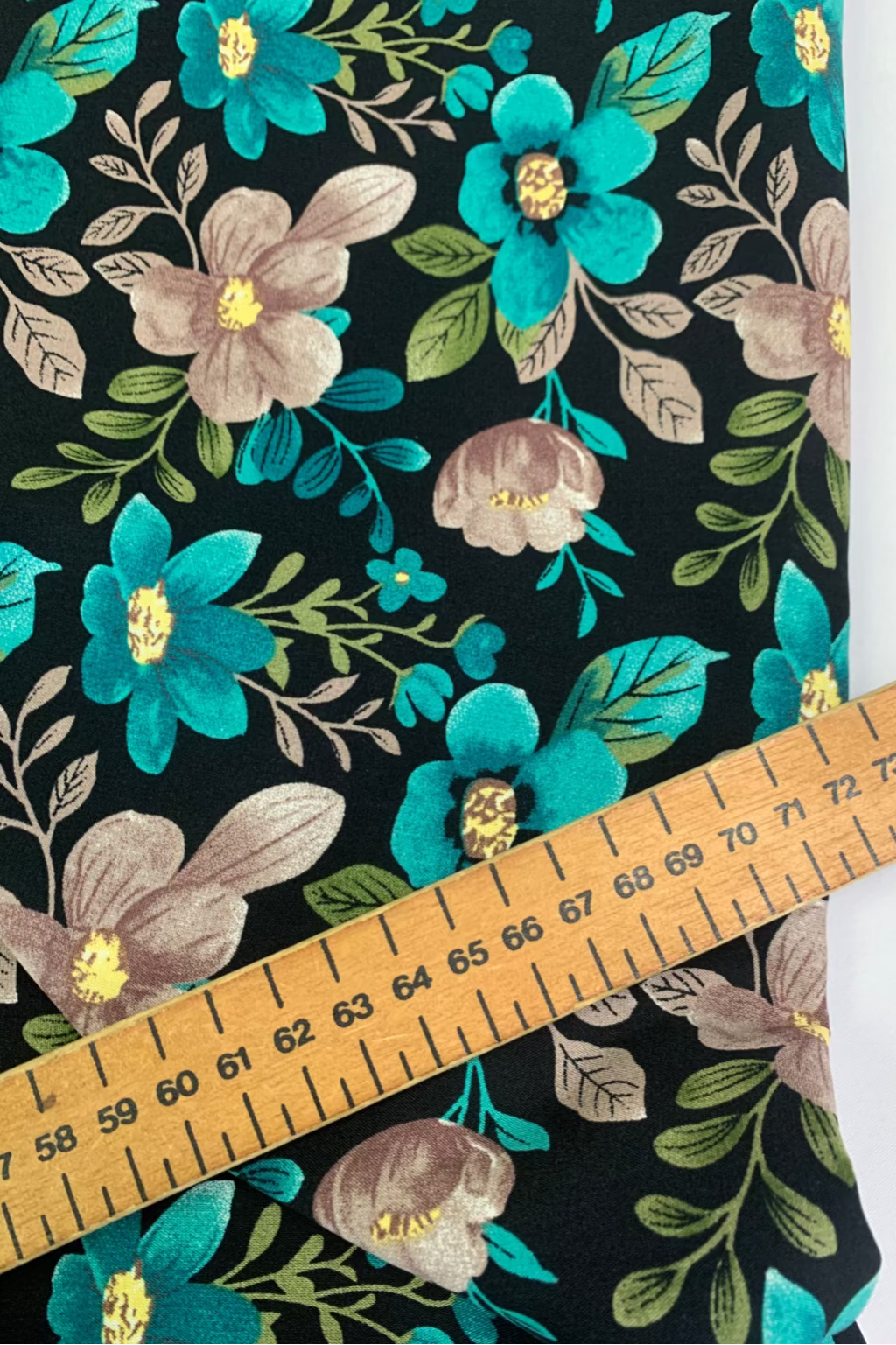 Floral fabric pattern with a ruler for scale on a black background