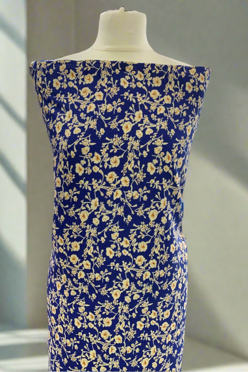 Blue floral dress on a mannequin in an indoor setting.