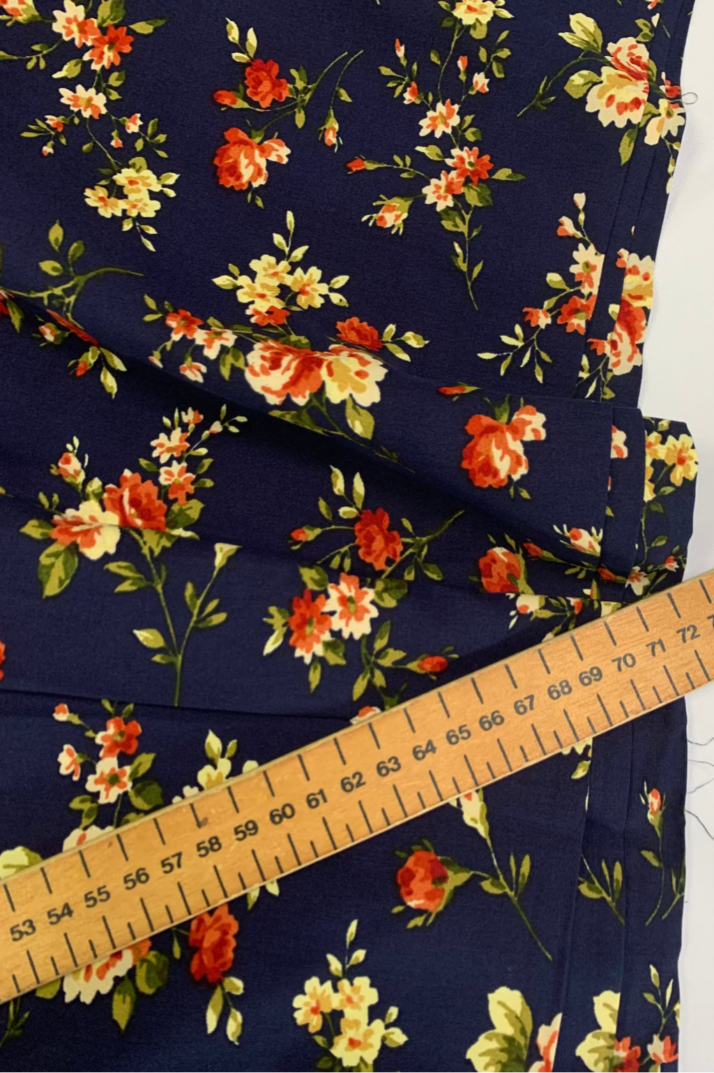 Floral fabric with a ruler for scale on a navy background
