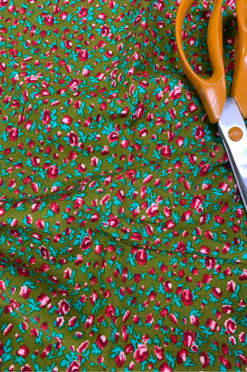 Scissors on a piece of fabric with a floral pattern