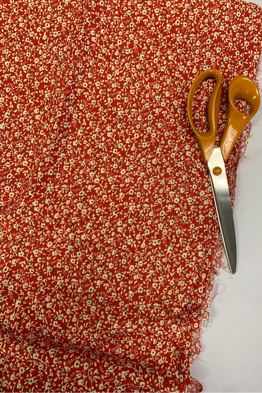 Scissors on a piece of red floral fabric