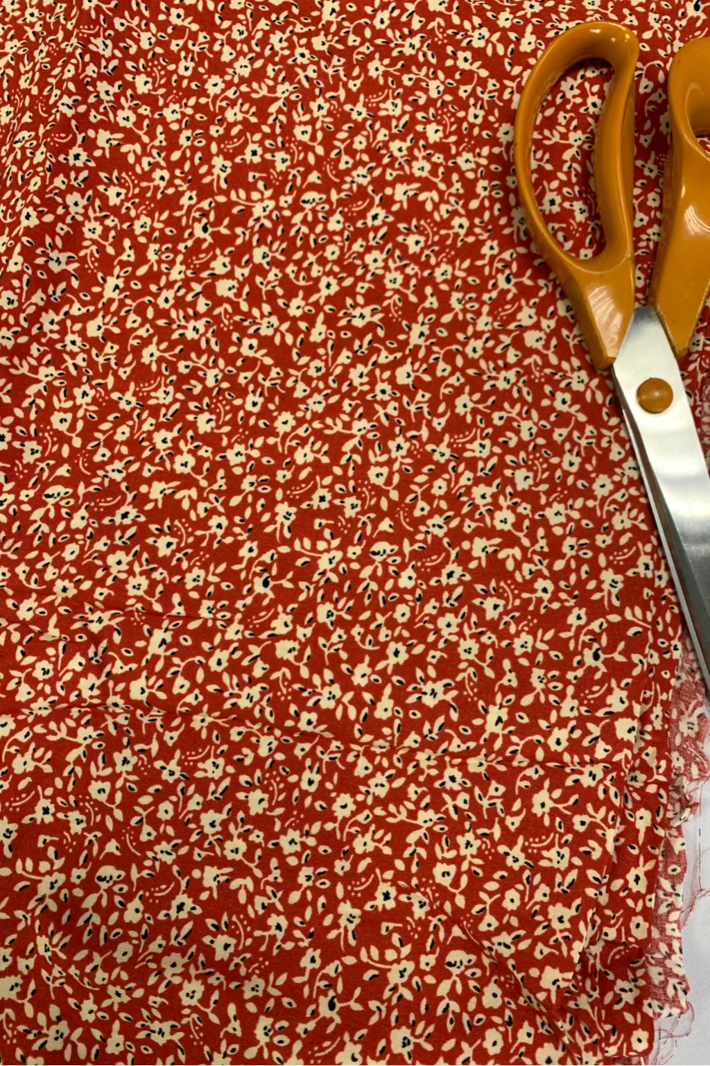 Floral fabric with a pair of scissors on top
