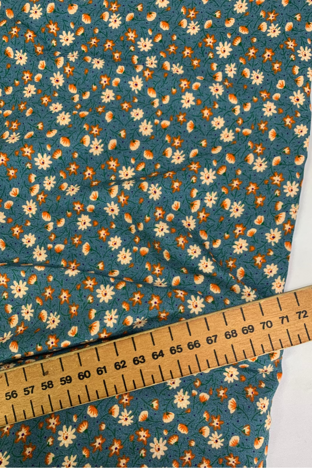 Floral fabric with a ruler for scale on a white background