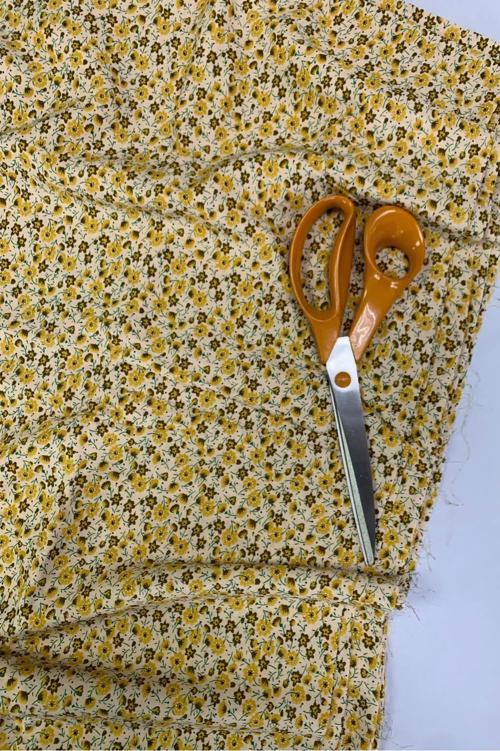 Floral fabric with a pair of scissors on a white background