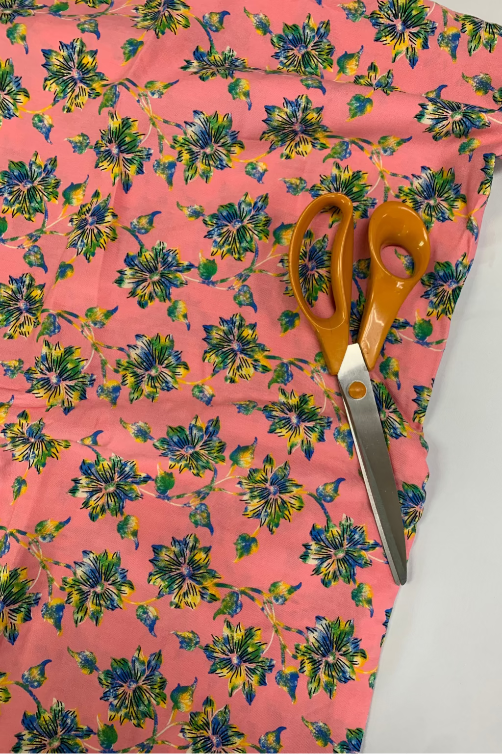 Floral-patterned fabric with scissors on a white background