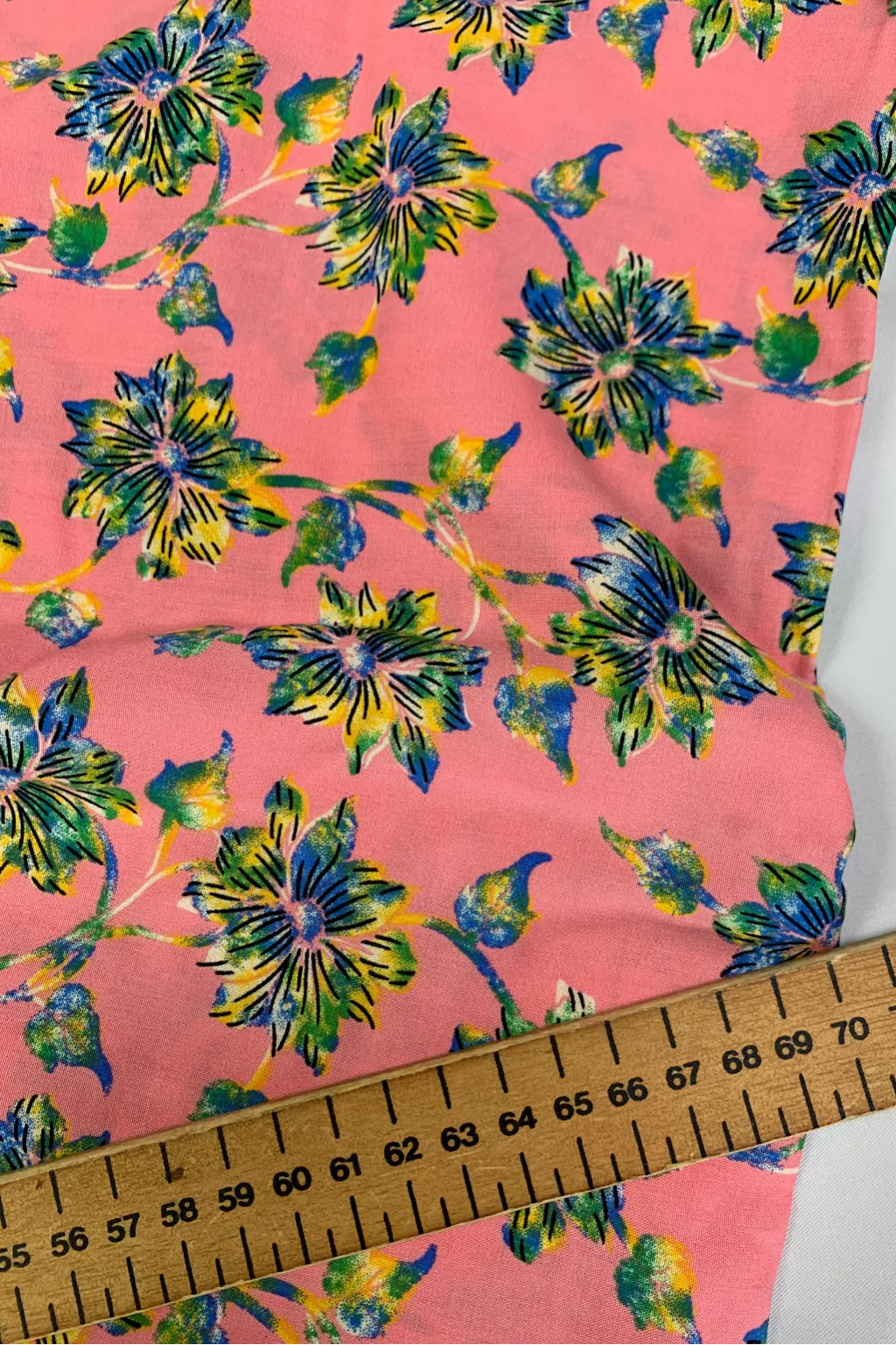 Floral fabric with a ruler for scale on a pink background
