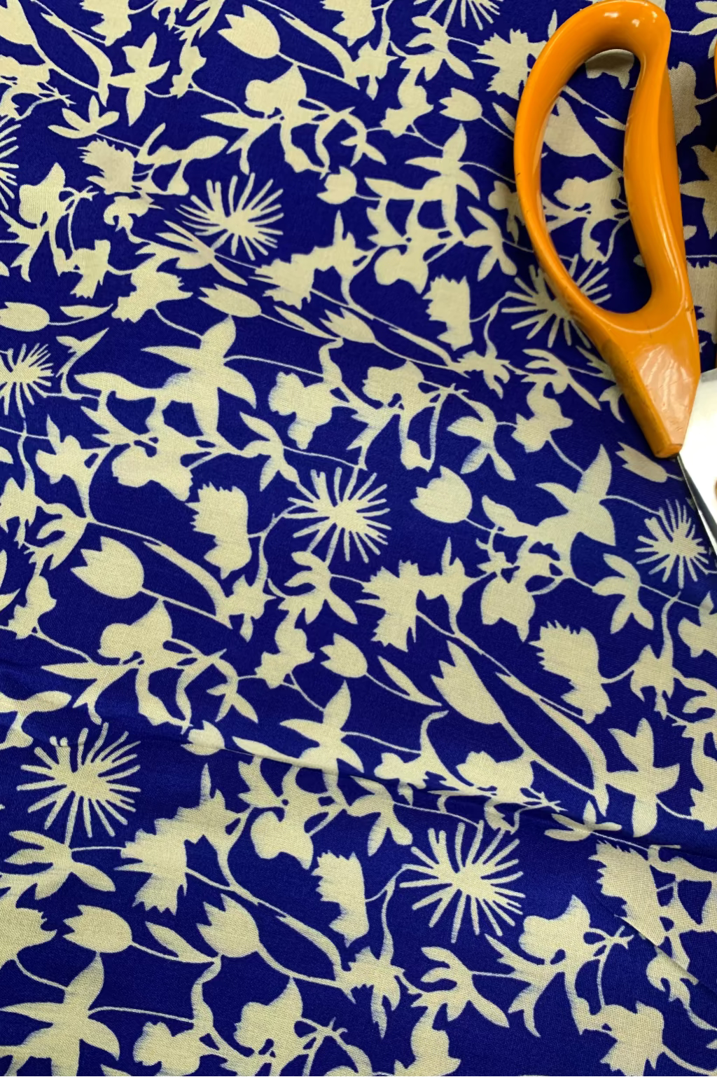 Floral-patterned fabric with scissors on a blue background
