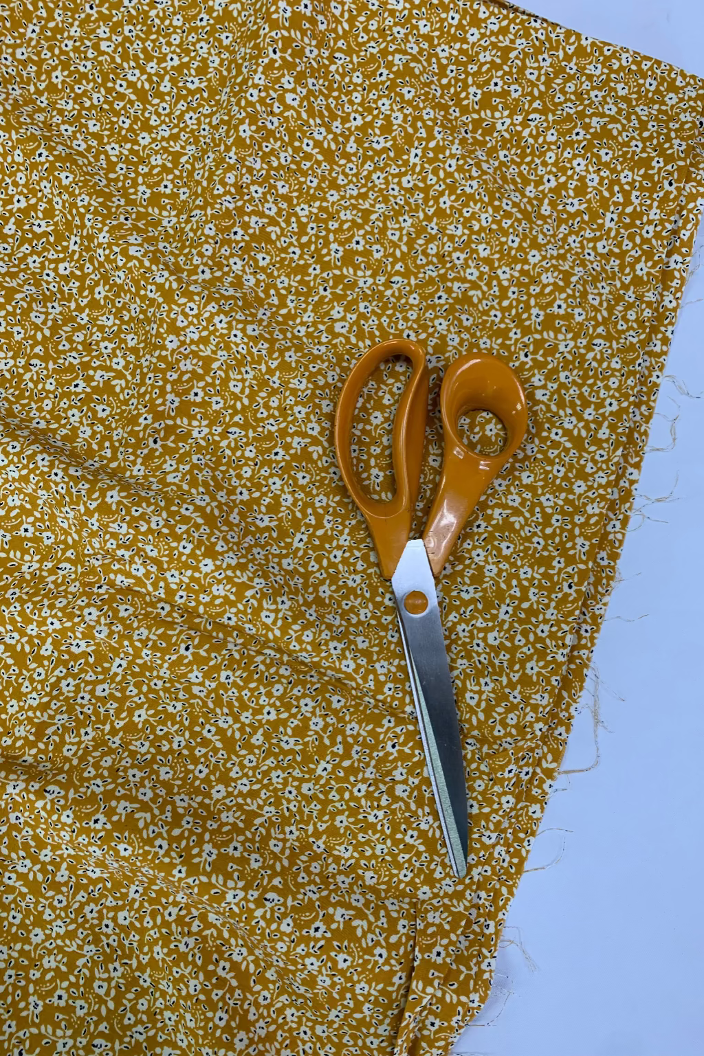 Scissors on a piece of yellow floral fabric