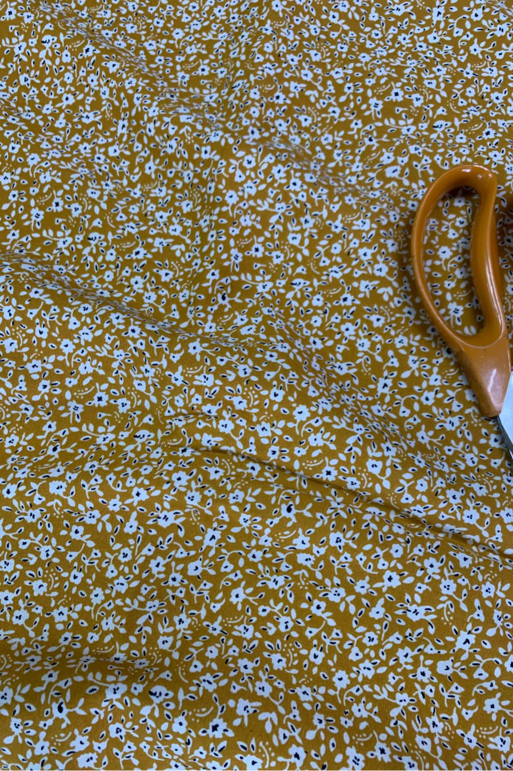 Floral-patterned fabric with a pair of scissors on top
