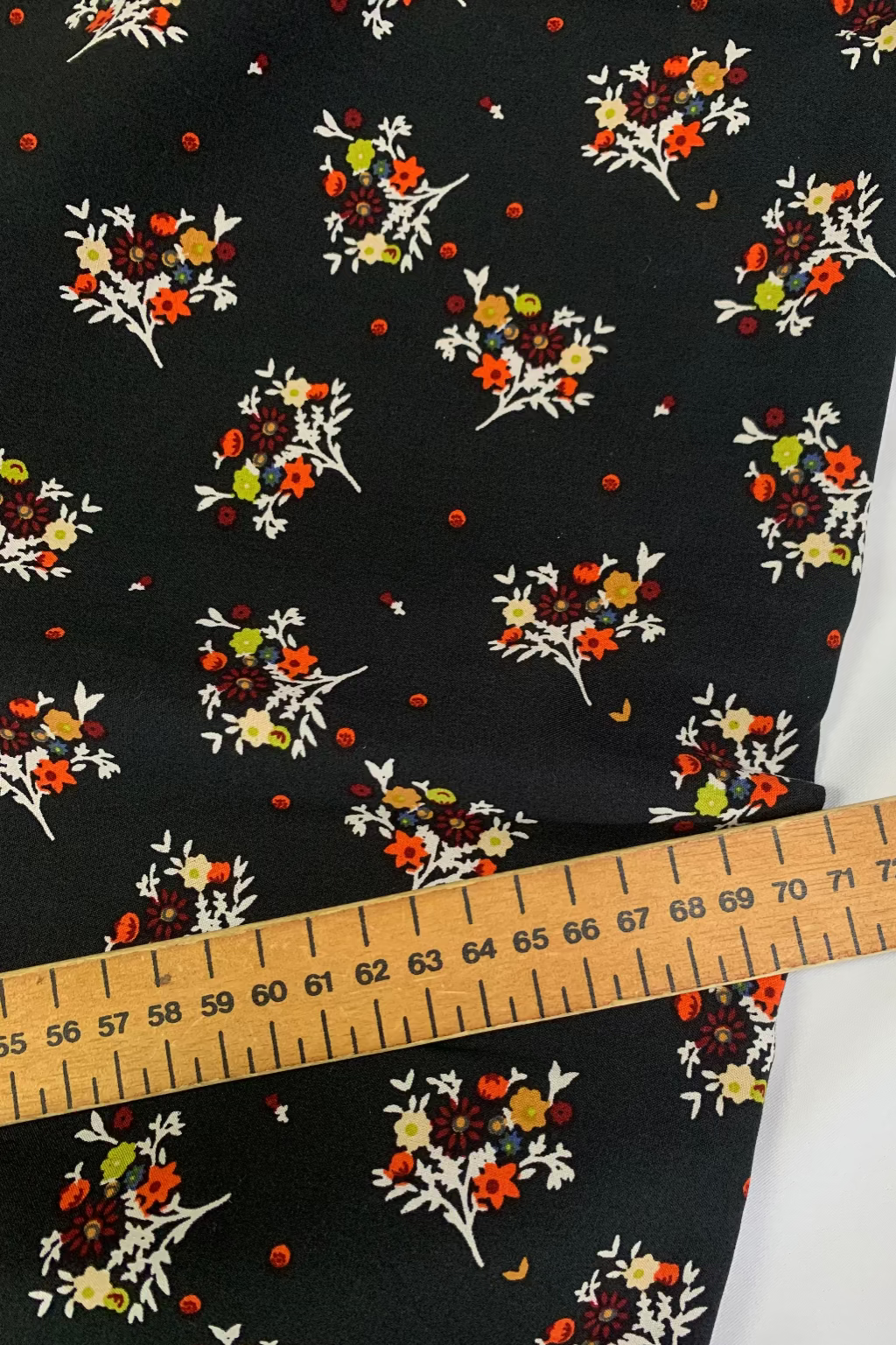 Floral patterned fabric with a ruler for scale on a black background
