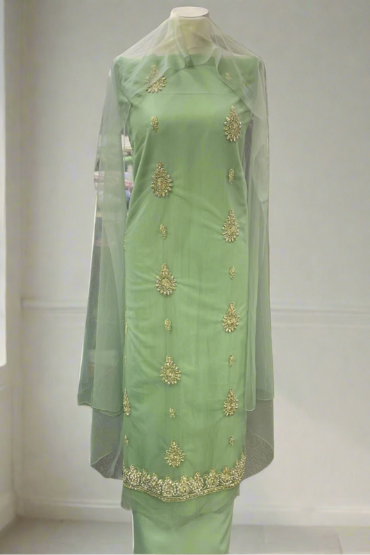 Light green traditional outfit with gold embroidery in a store setting