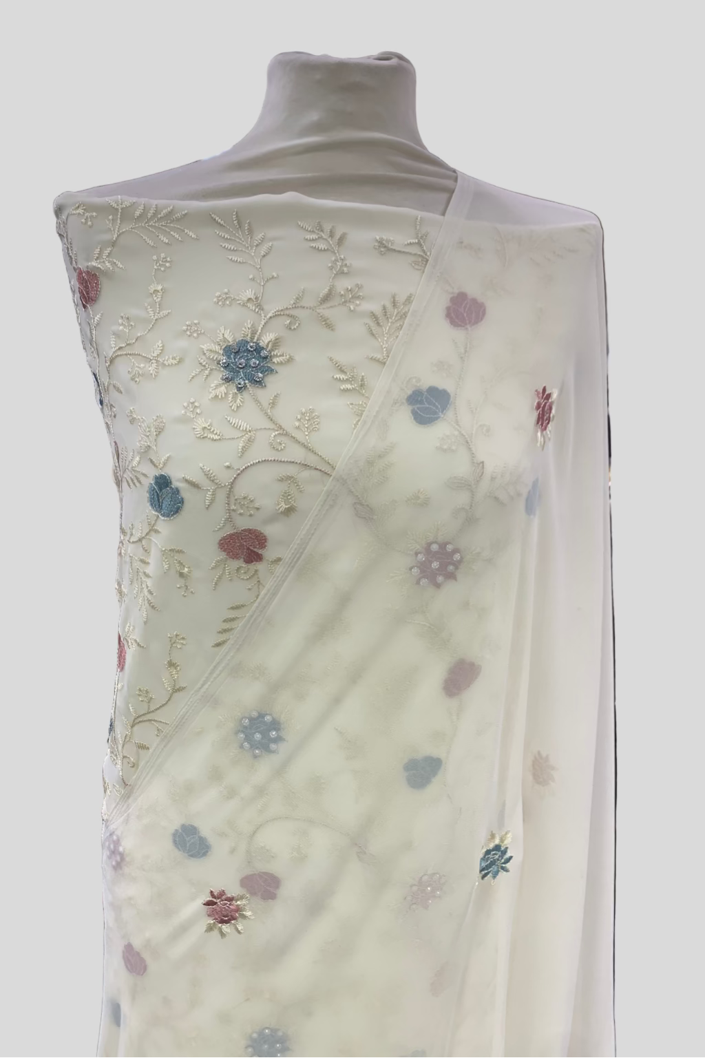 White embroidered fabric on a mannequin in a store setting