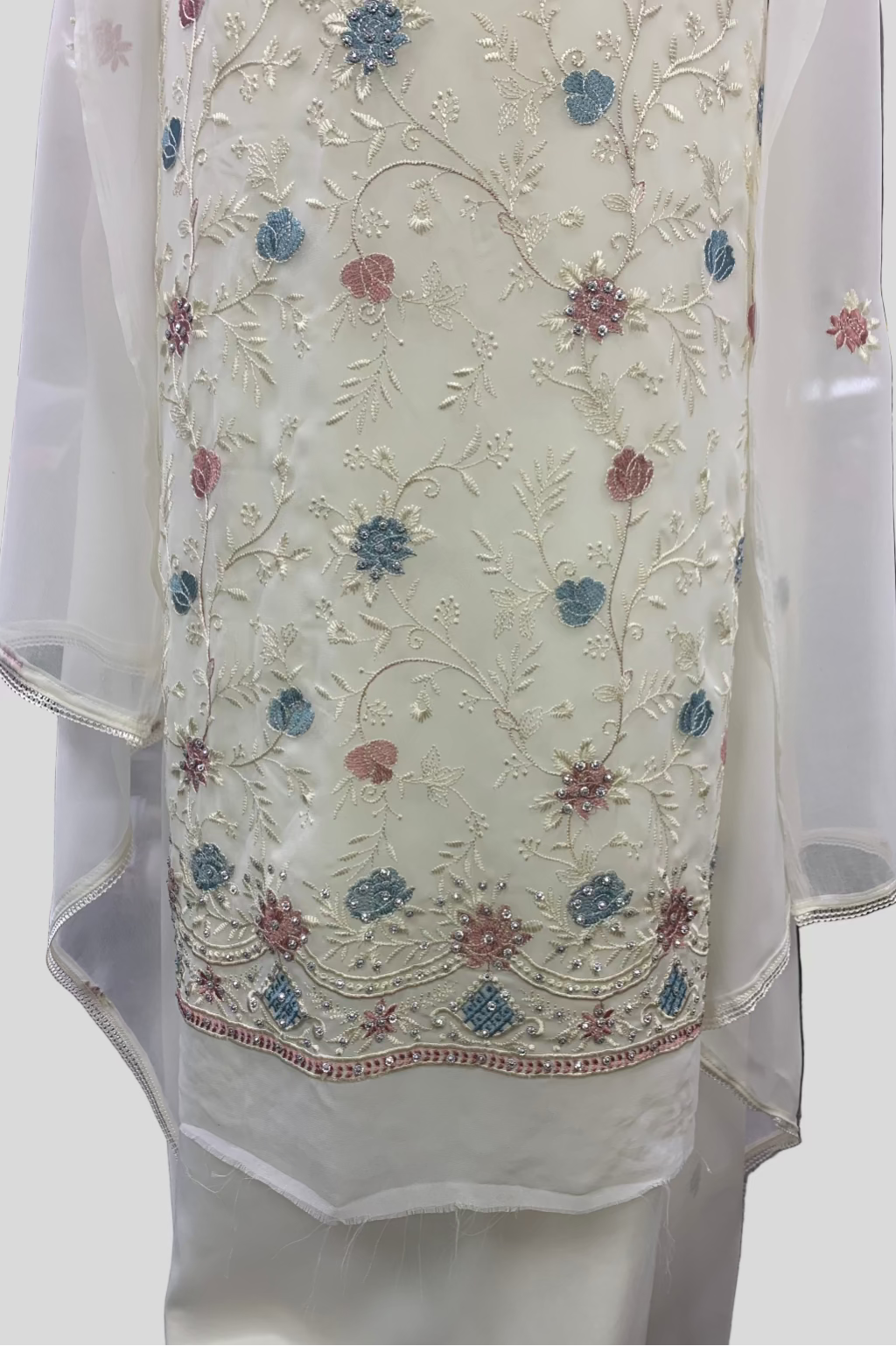 White embroidered garment with floral patterns on a plain background