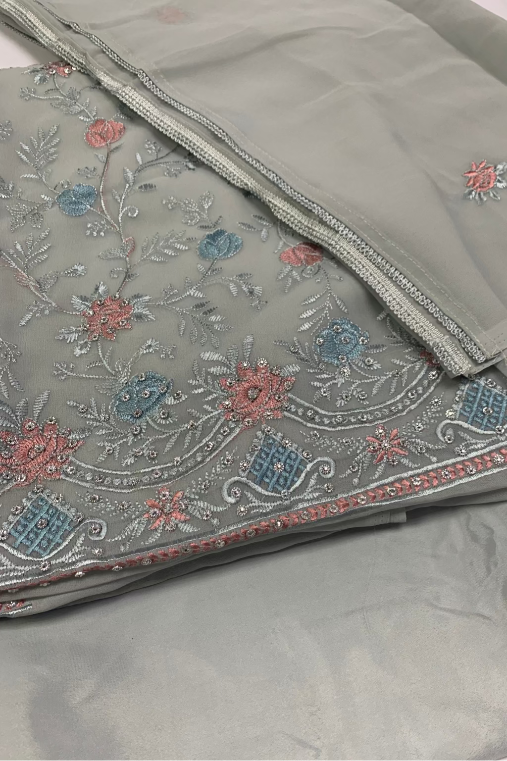 blue fabric with intricate floral embroidery on a white background
