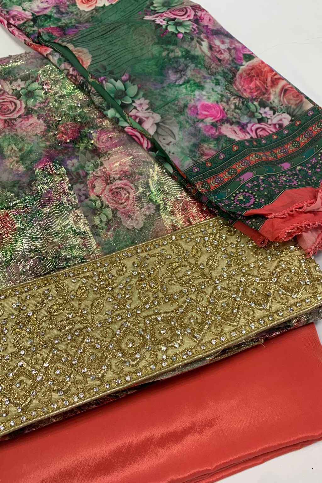 Colorful fabric with floral patterns and gold embroidery on a white background