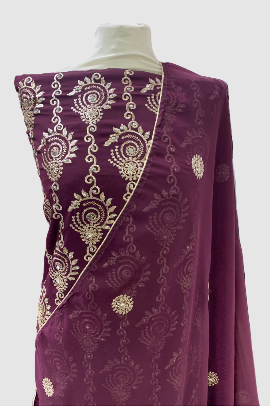 Purple fabric with gold embroidery on a mannequin in a store setting