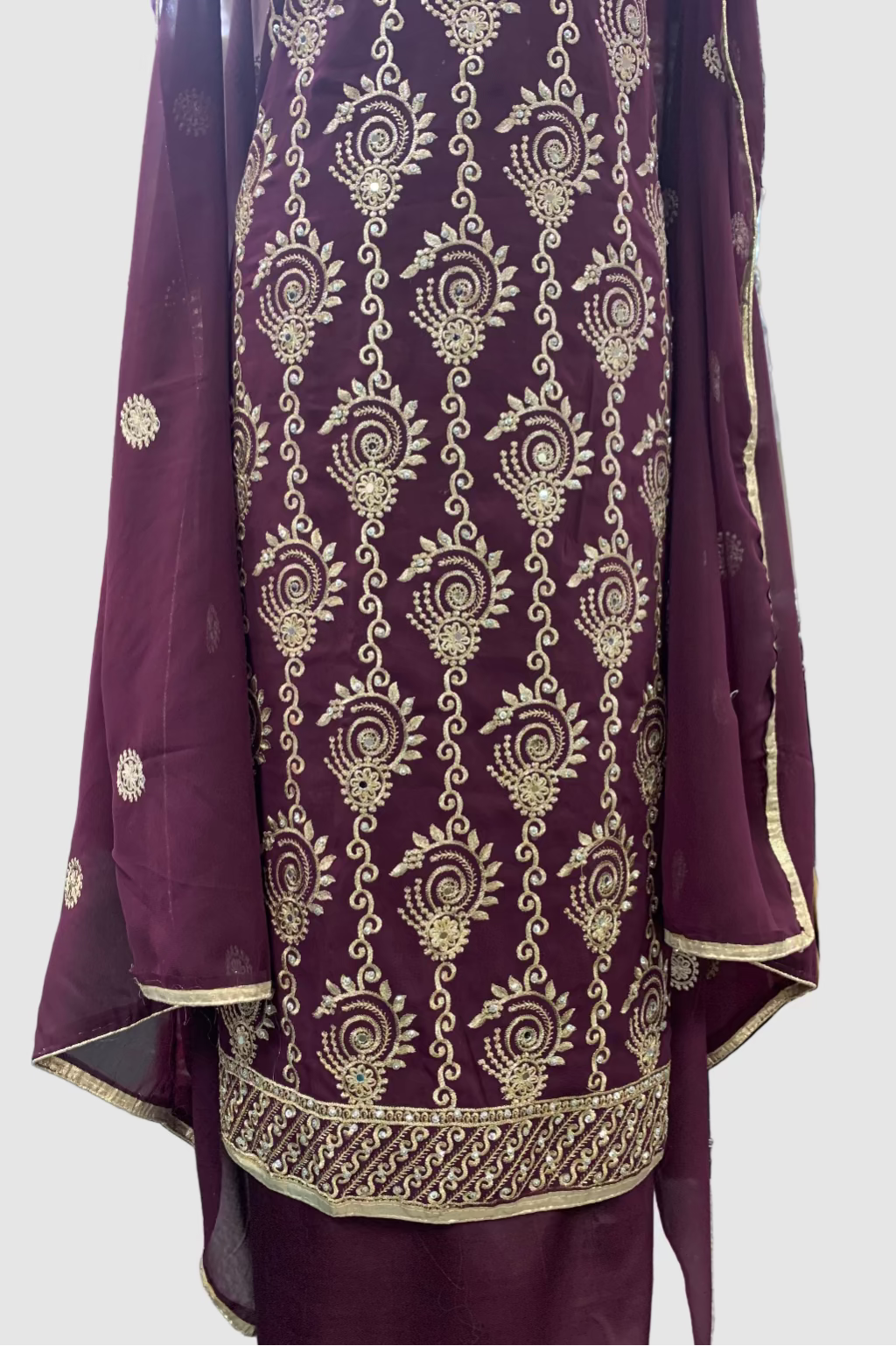 Purple fabric with gold embroidery in a store setting