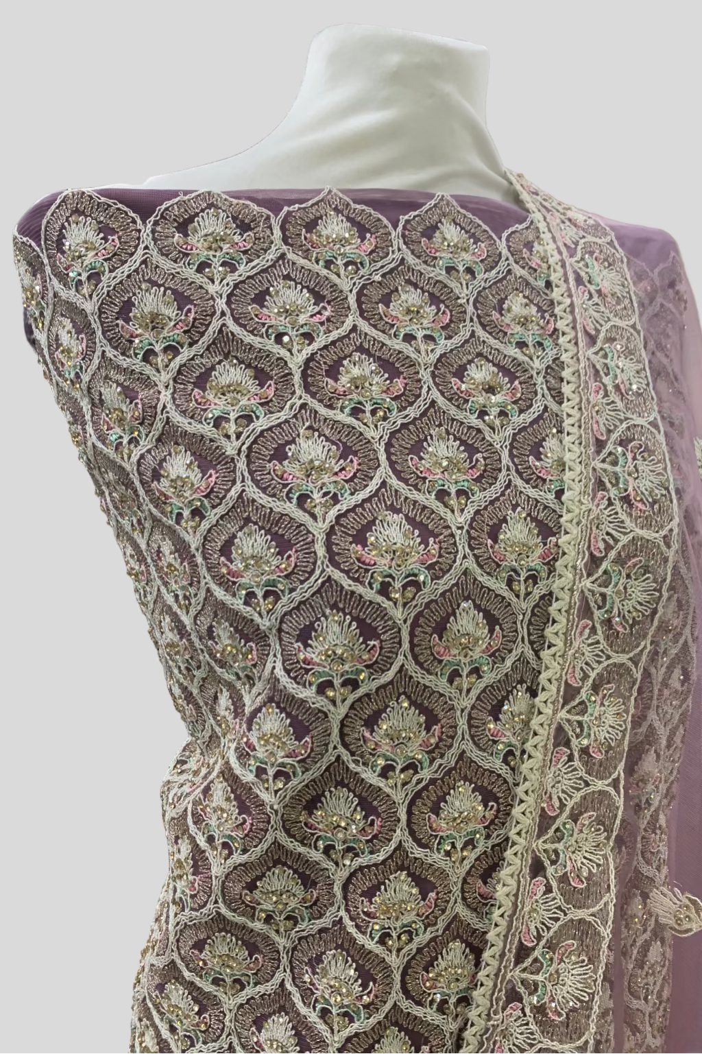 Embroidered fabric on a mannequin with a blurred indoor background