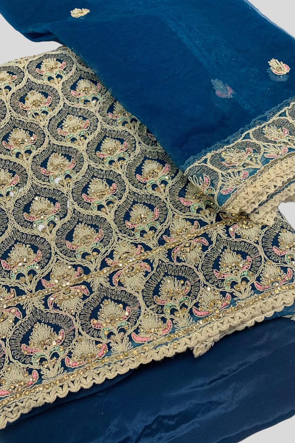 Teal fabric with intricate gold embroidery on a white background