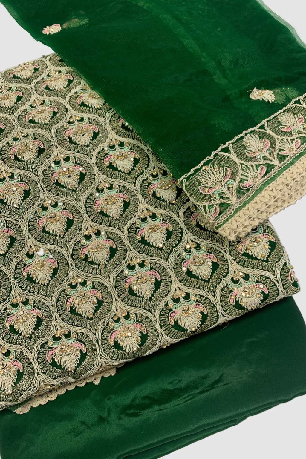 Green fabric with intricate gold embroidery on a white background