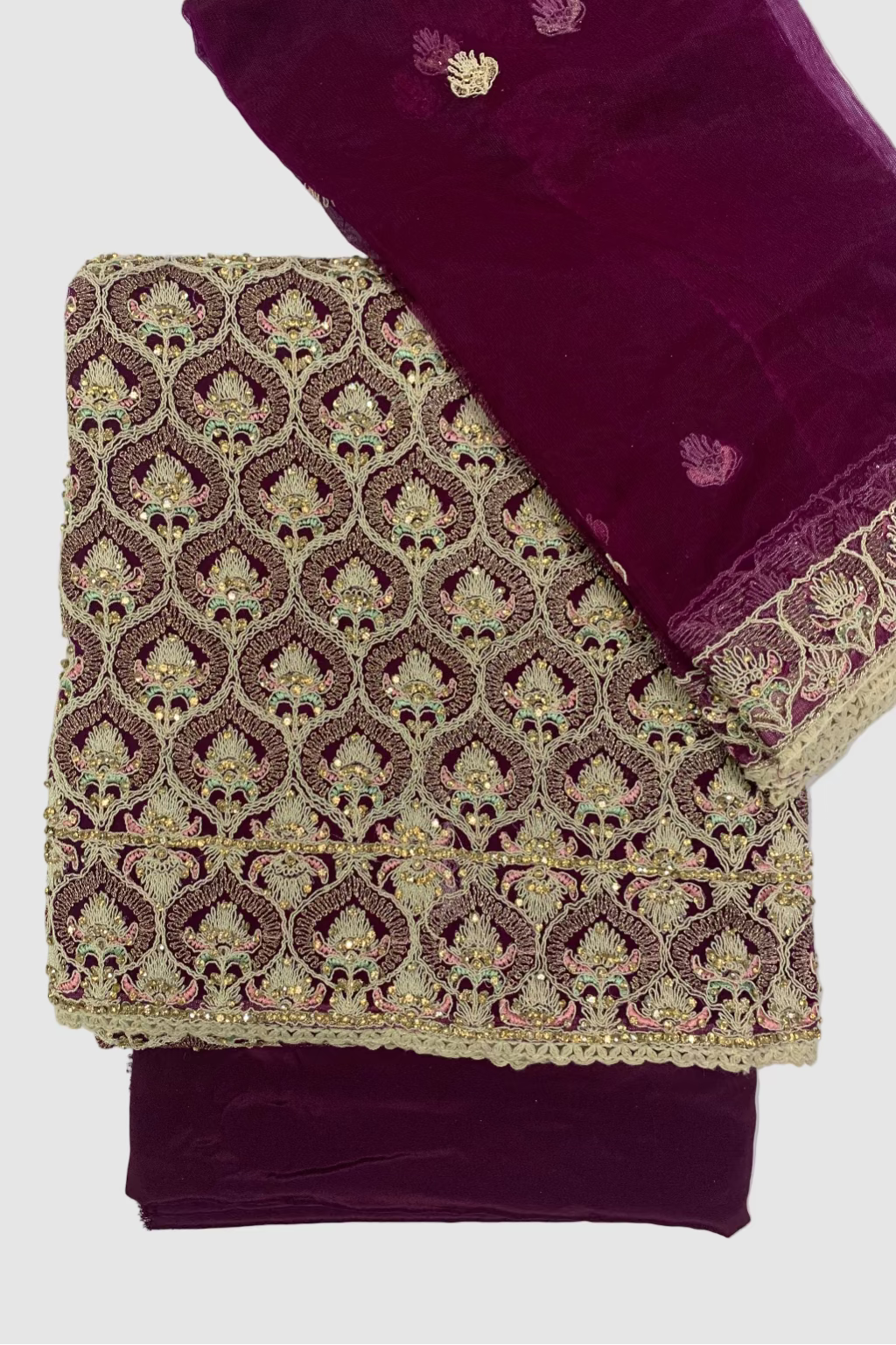 Purple fabric with intricate gold embroidery on a white background