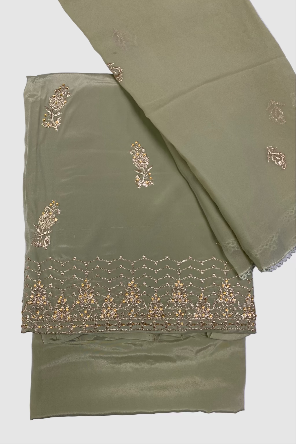 Green fabric with gold embroidery on a light purple background