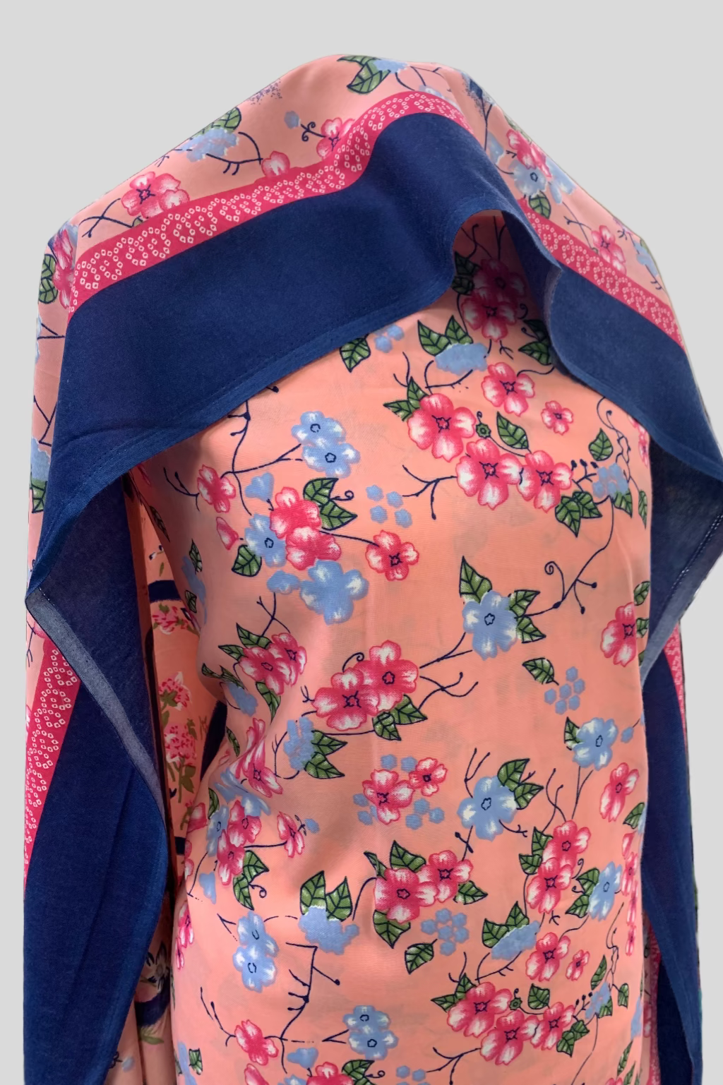Floral-patterned fabric with blue border on a mannequin in a store setting