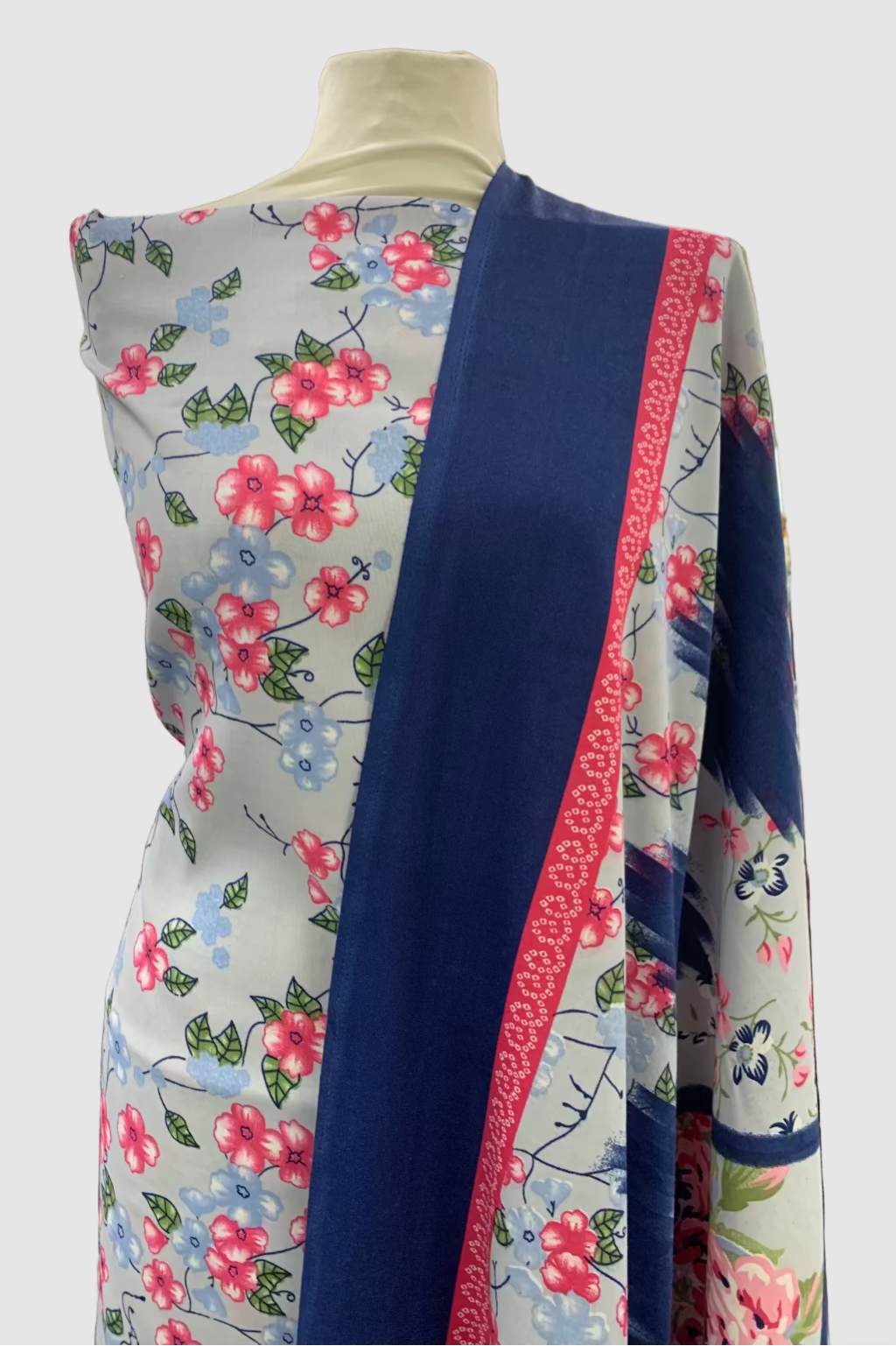 Mannequin wearing a floral and blue patterned garment in a store setting
