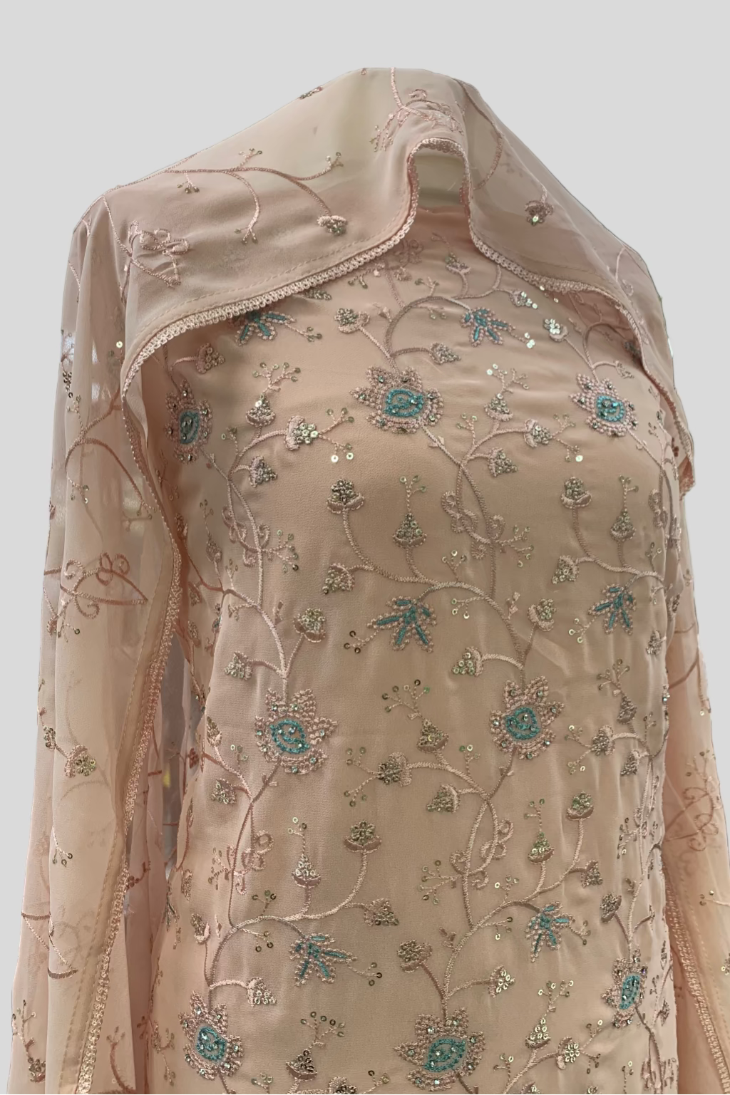 Peach embroidered garment on a hanger in an indoor setting