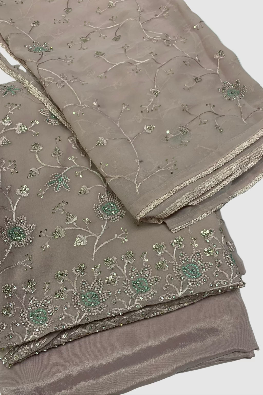Beige fabric with floral embroidery on a light blue background