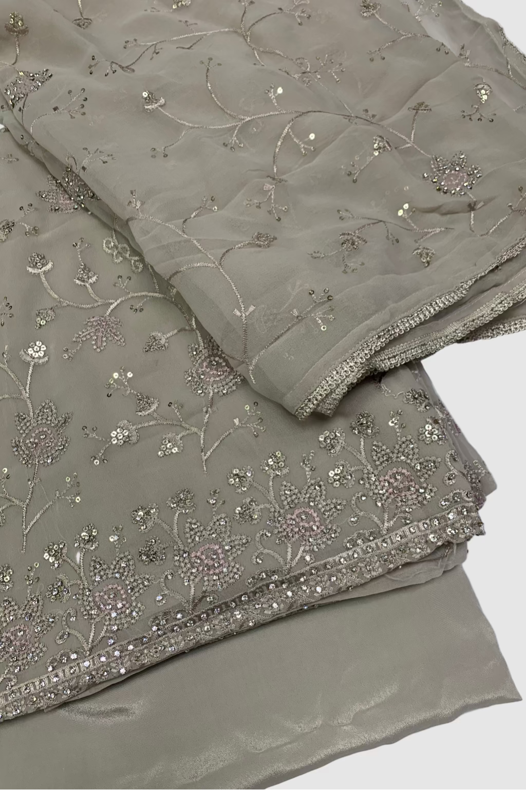 Folded fabric with intricate embroidery on a white background
