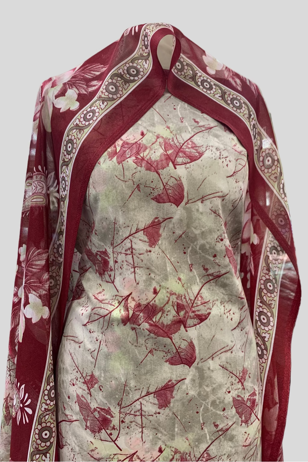 Fabric with red floral pattern on a white background, draped over a surface.