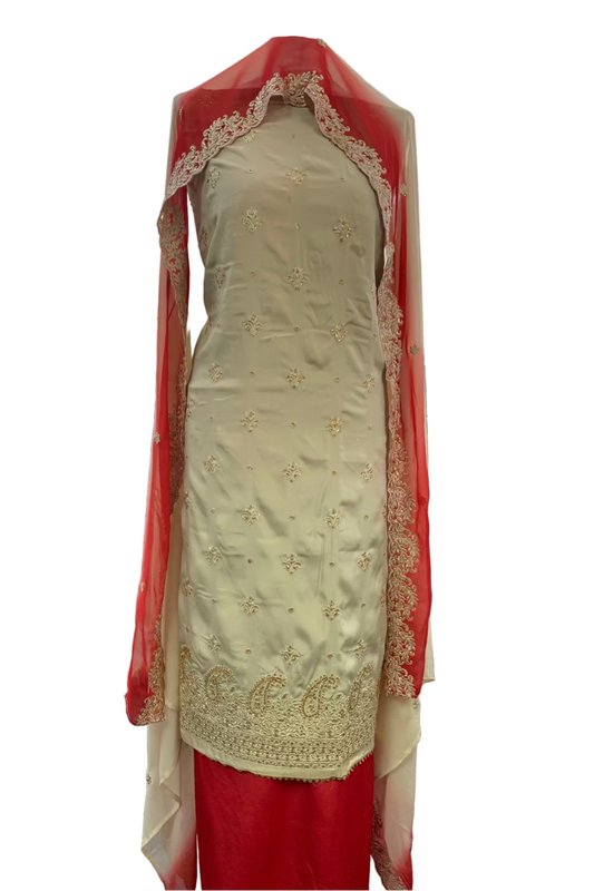 Traditional embroidered outfit with red dupatta in a store setting