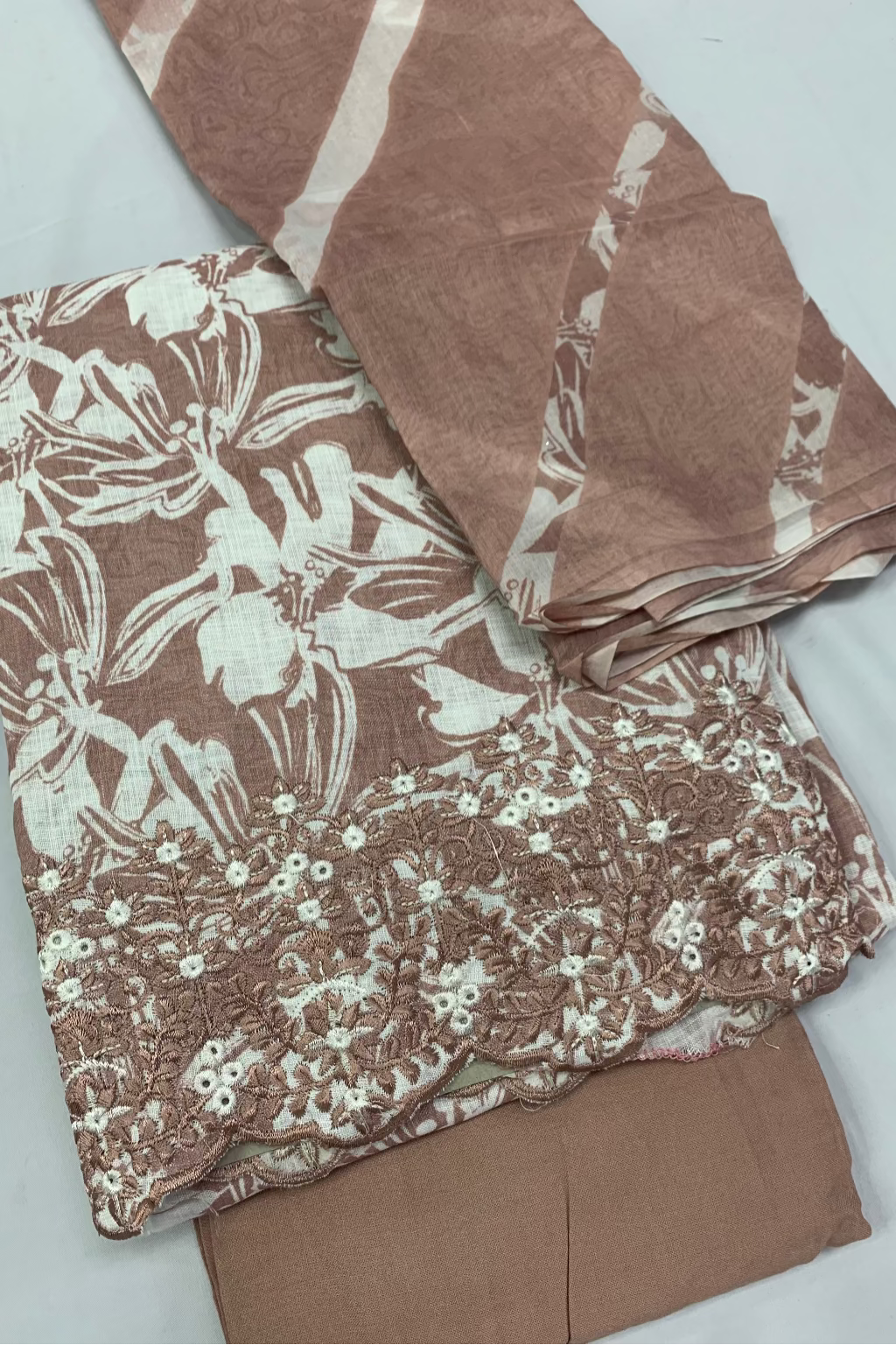 Pink fabric with white floral pattern on a light gray background