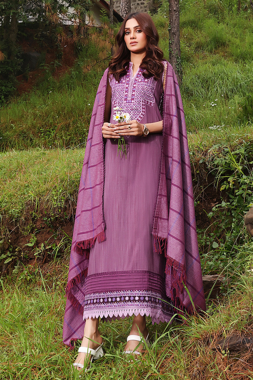 A woman wearing a purple unstitched cotton stripe salwar kameez suit with embroidery on the shirt and a dupatta with vertical stripes.
