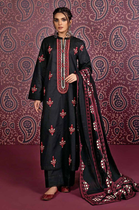 A woman modeling a black and red unstitched salwar kameez suit with floral and geometric printed patterns and silver embellishments.