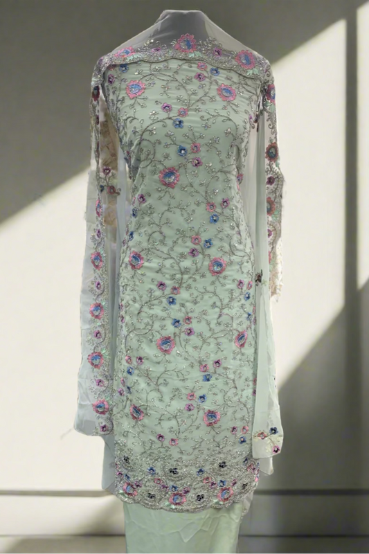 Light green embroidered traditional outfit in a store setting