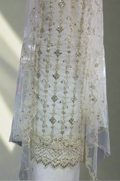Elegant white embroidered dress on a mannequin in a store setting