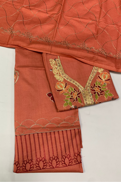 Peach fabric with intricate embroidery on a white background