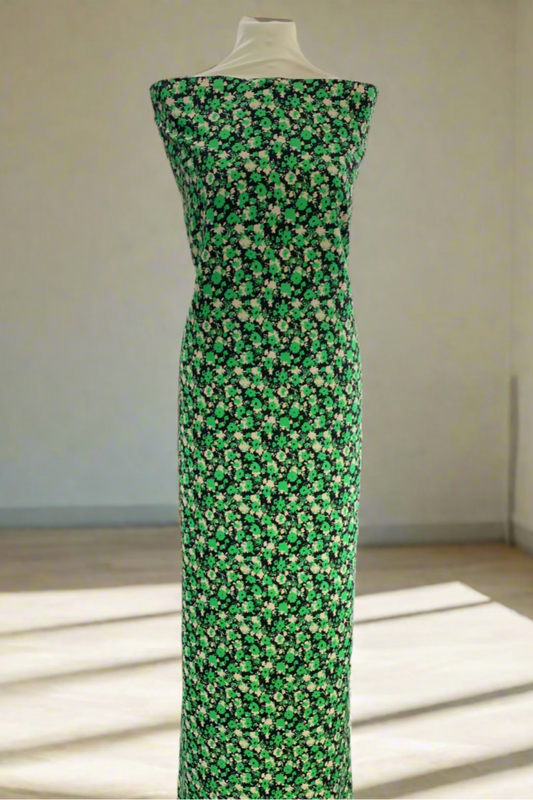 Mannequin wearing a green floral dress in a store setting